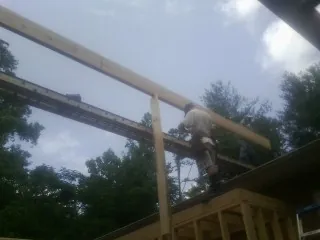 Carpenter setting a ridge beam over a new addition frame — Ice Dam Removal by Roofing Brothers in Chester Gap