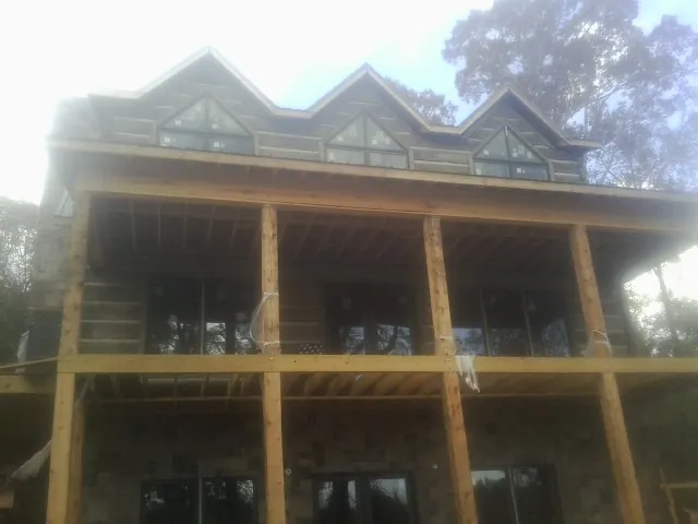 Dormers and porch framing on a large log home under construction — Roof Coating work by our crew in Chester Gap