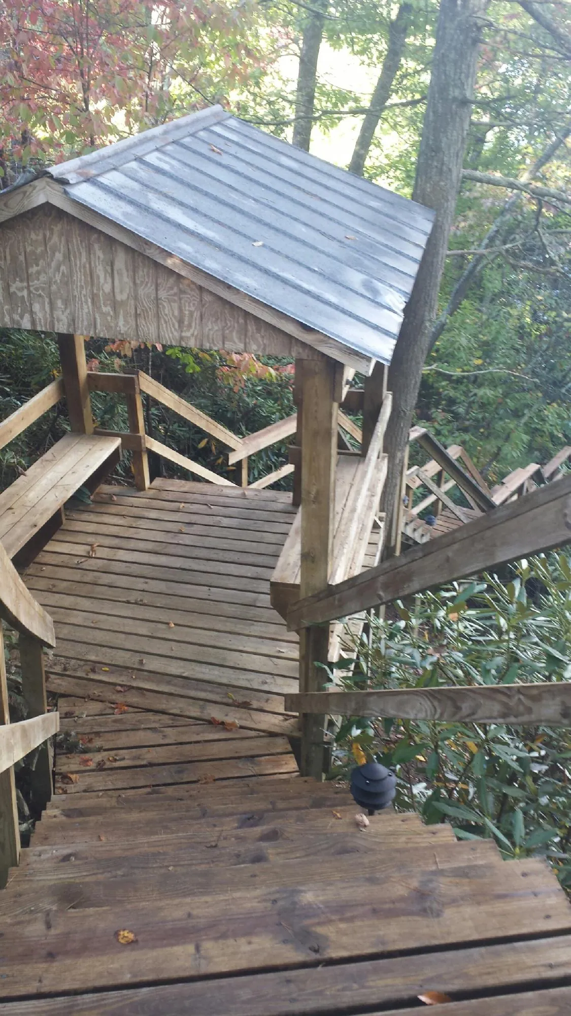 Metal roofed shelter over wooden steps on a wooded walkway — Skylight Repair & Installation work by our crew in Chester Gap